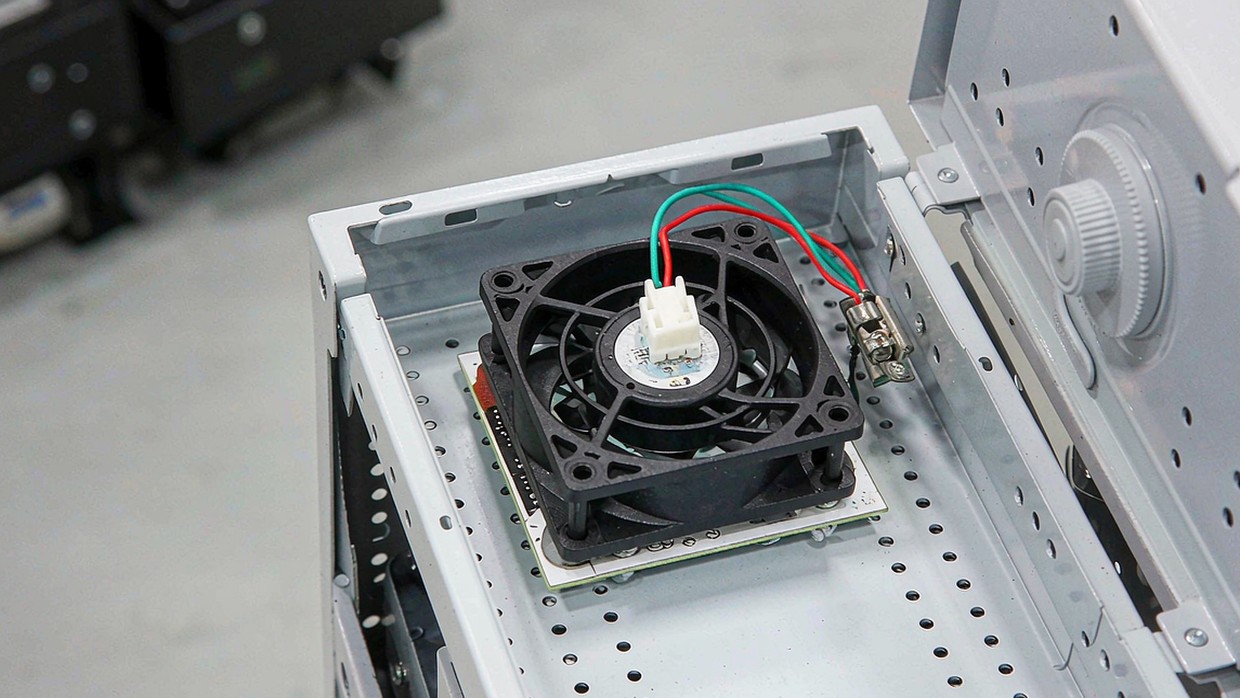 Compact brushless DC cooling fan installed inside an electronics enclosure